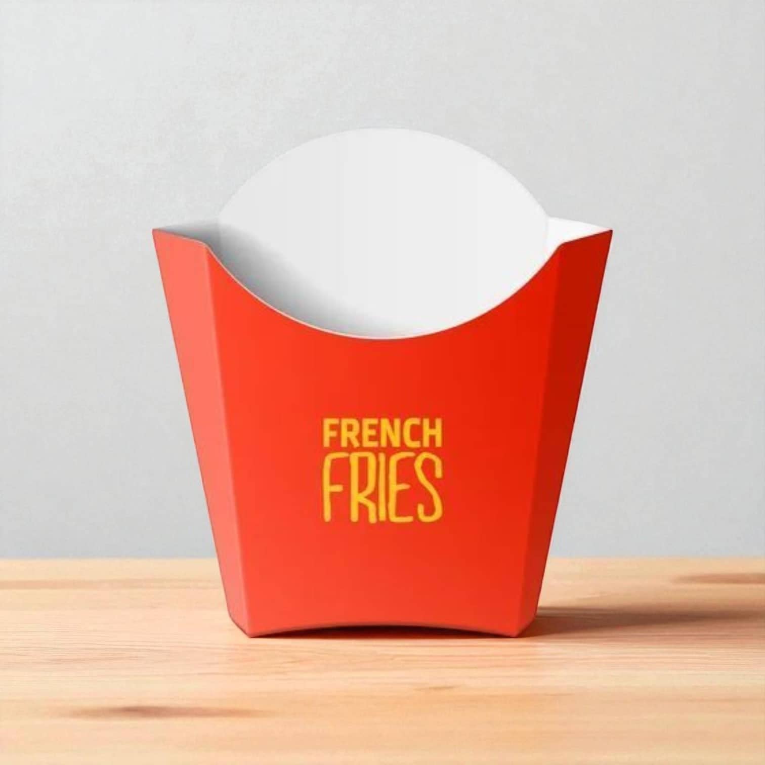 PackSmart red French fries scoop with yellow lettering on a wooden table.